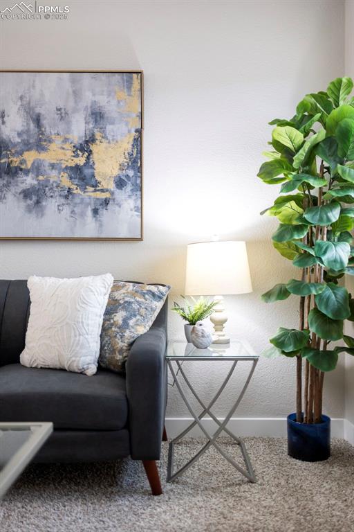 Carpeted living area featuring a textured wall