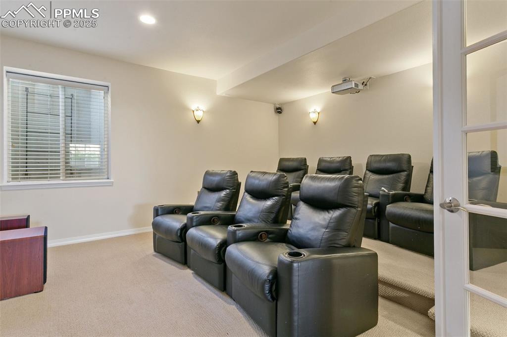 Home theater with light colored carpet and recessed lighting