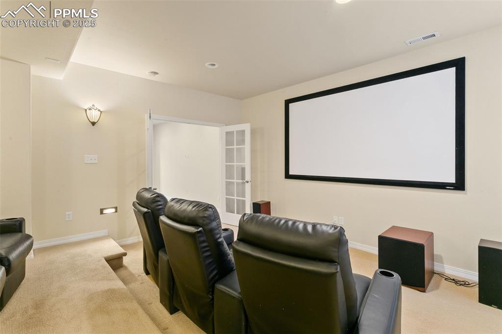 Home theater with light carpet and recessed lighting