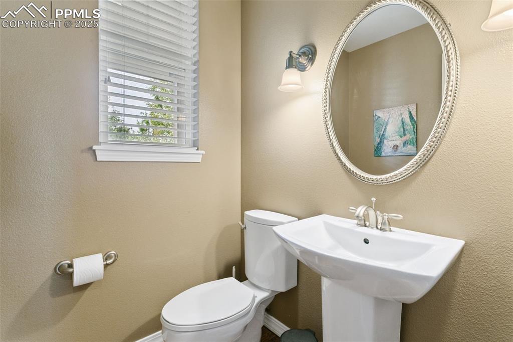 Half bathroom with a textured wall and toilet