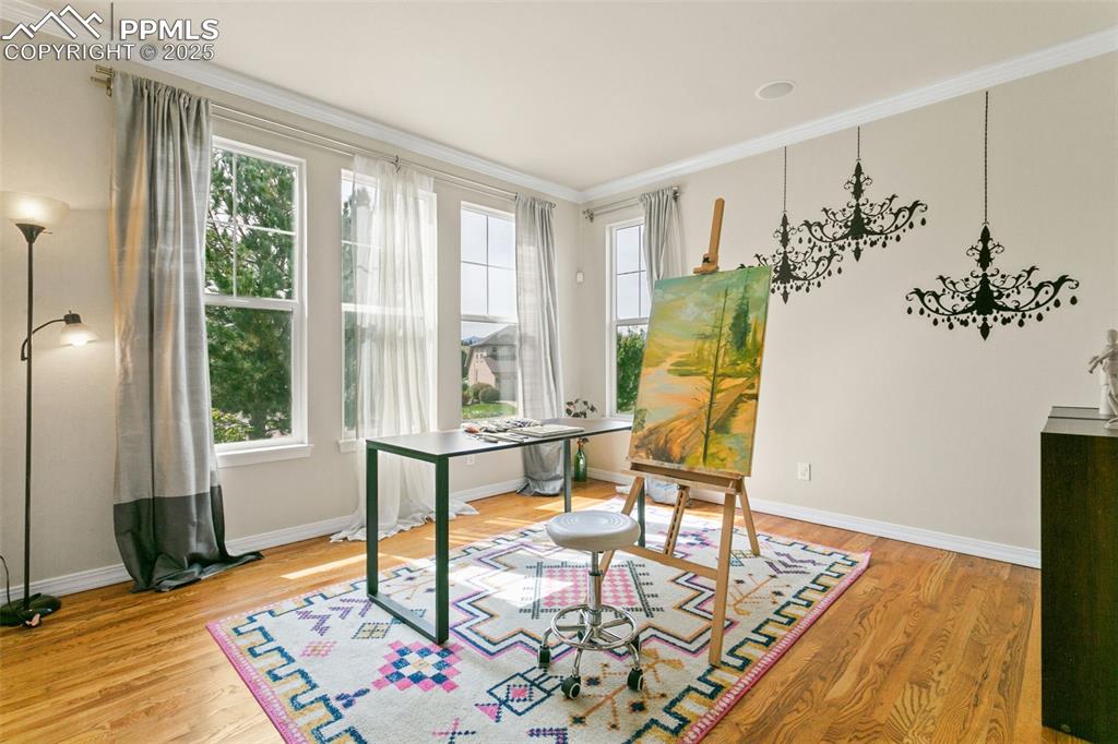 Home office featuring ornamental molding and light wood-type flooring