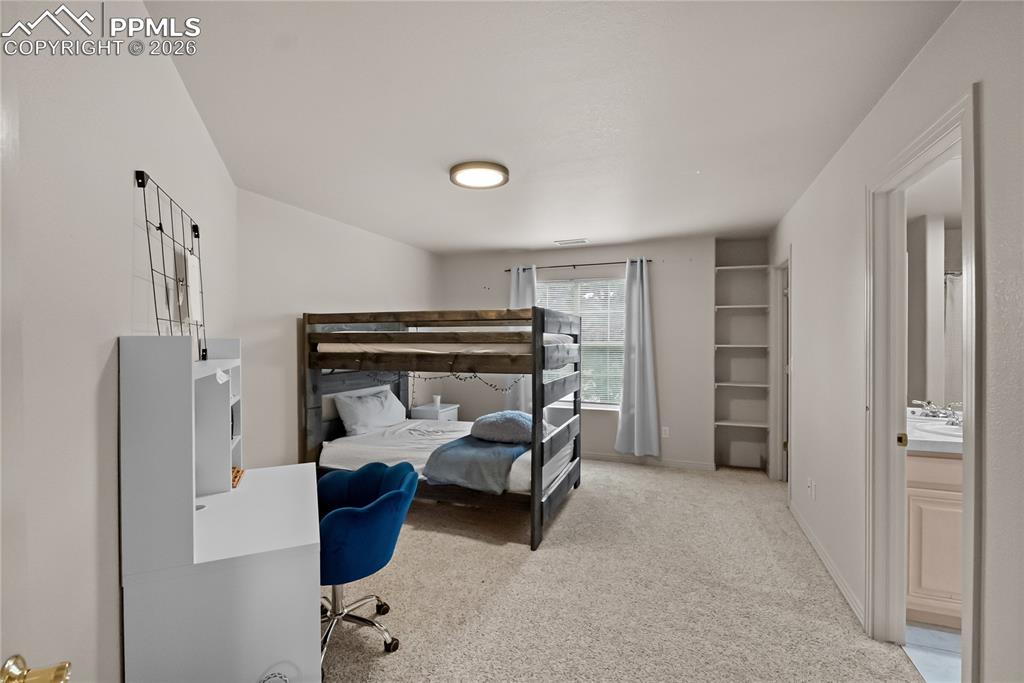 Second bedroom with walk in closet, bookshelf and jack and Jill bathroom.