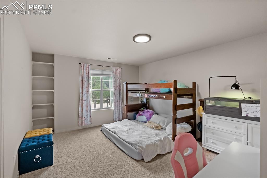 Third bedroom with walk in closet, bookshelf and jack and Jill bathroom.