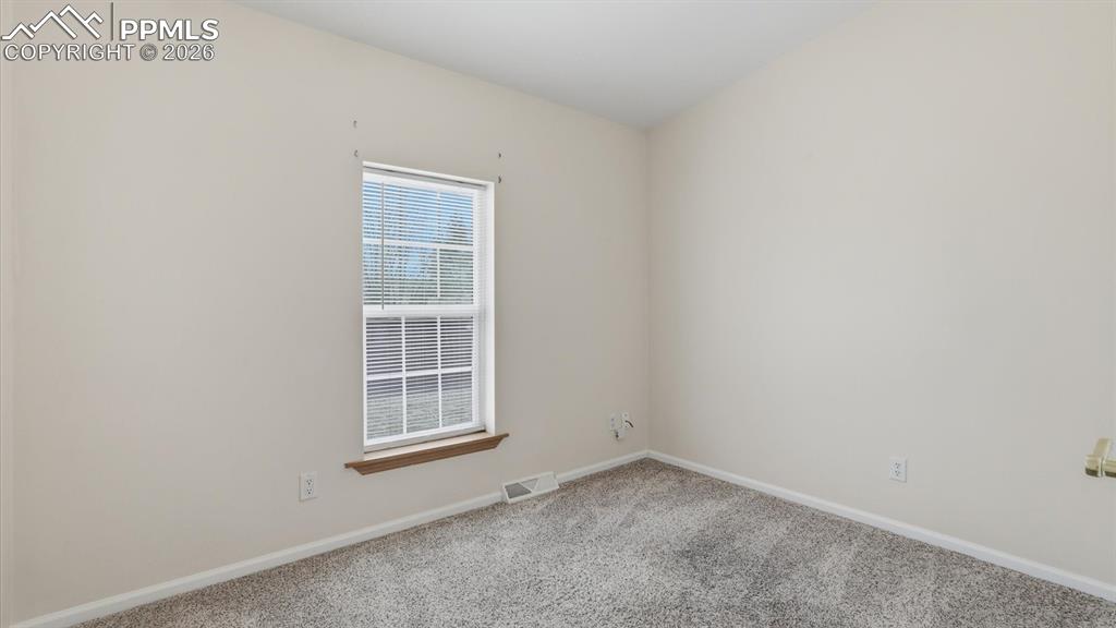 Bedroom #1 has neutral carpet and window.