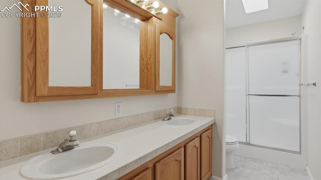 The Primary Bathroom features a dual sink vanity, framed mirror, and enclosed shower.