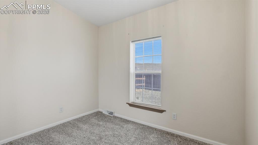Bedroom #3 has neutral carpet and a window.