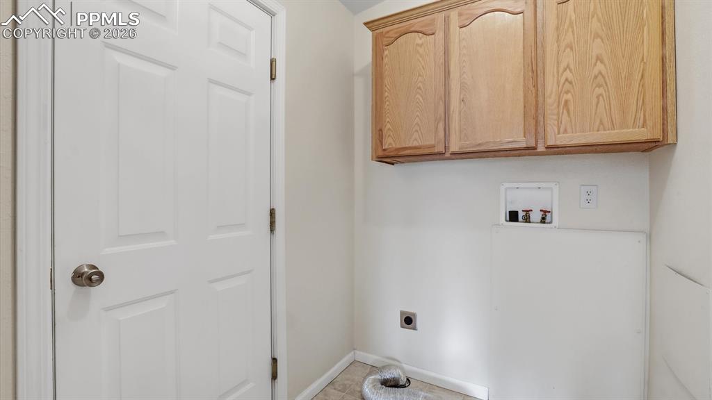 The Laundry Room has upper cabinets and garage access.