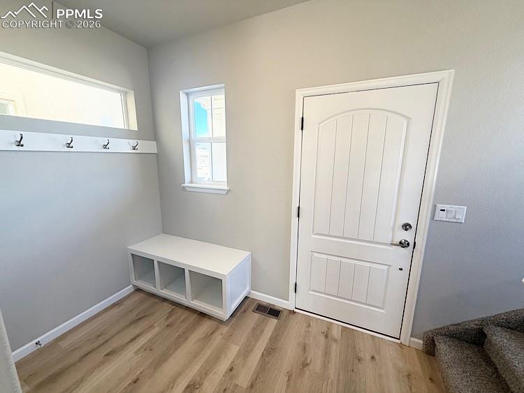 Entryway with a bench, coat hooks, and a coat closet!