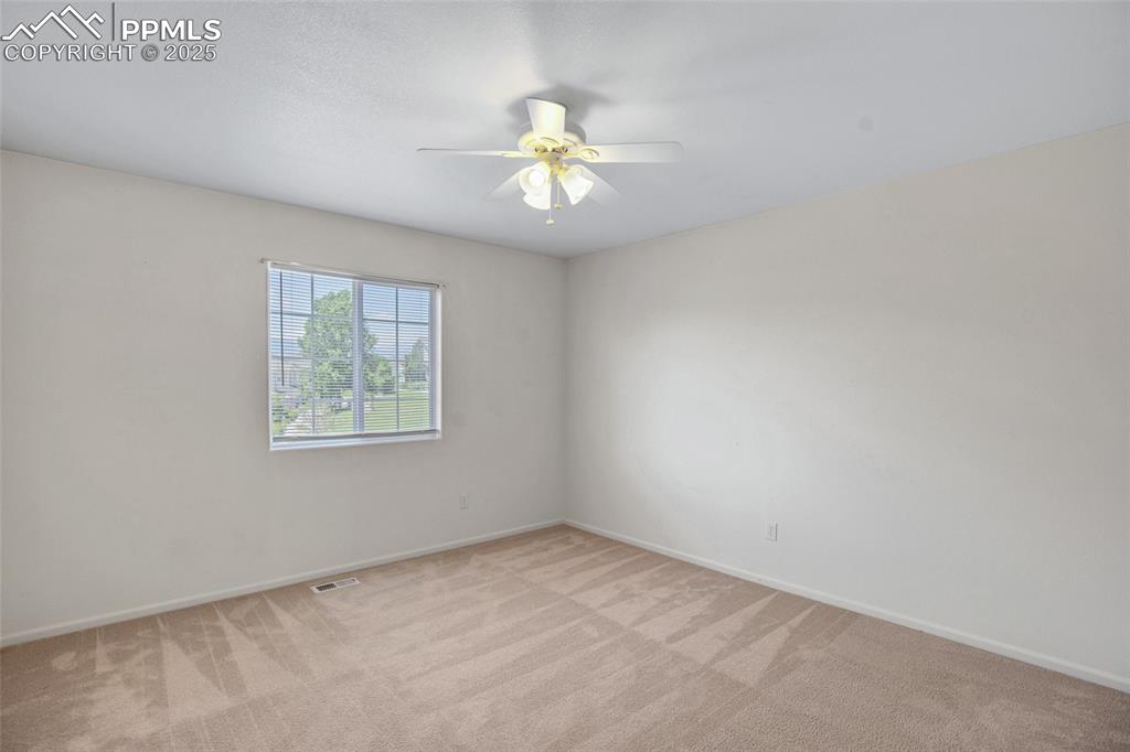 Unfurnished room with light carpet and a ceiling fan