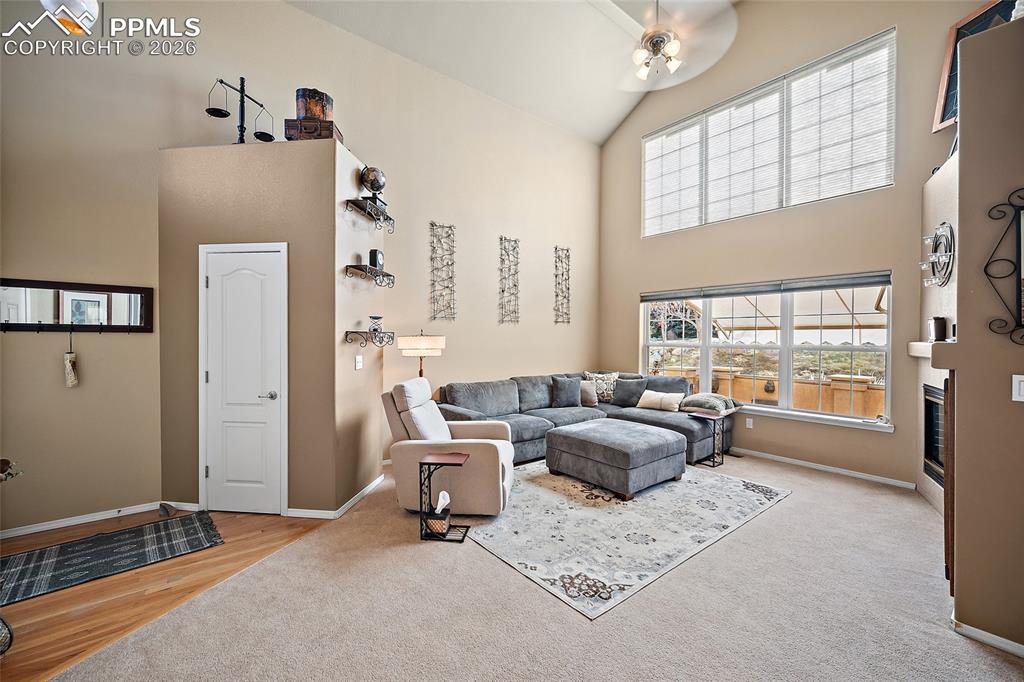 Living room with wall of windows that allow plenty of natural light. Upper solar shades are remote controlled.  