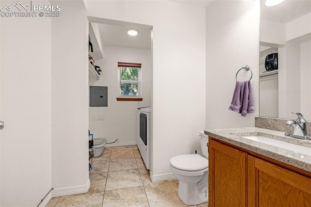 Bathroom with vanity, electric panel, and light tile patterned floors