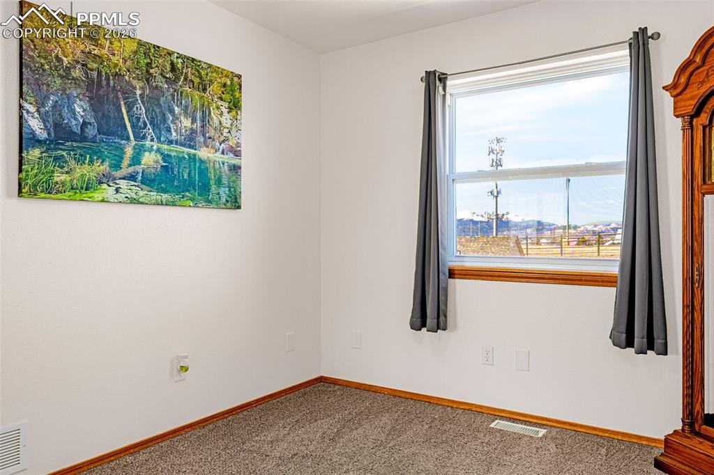Spare room featuring carpet and baseboards