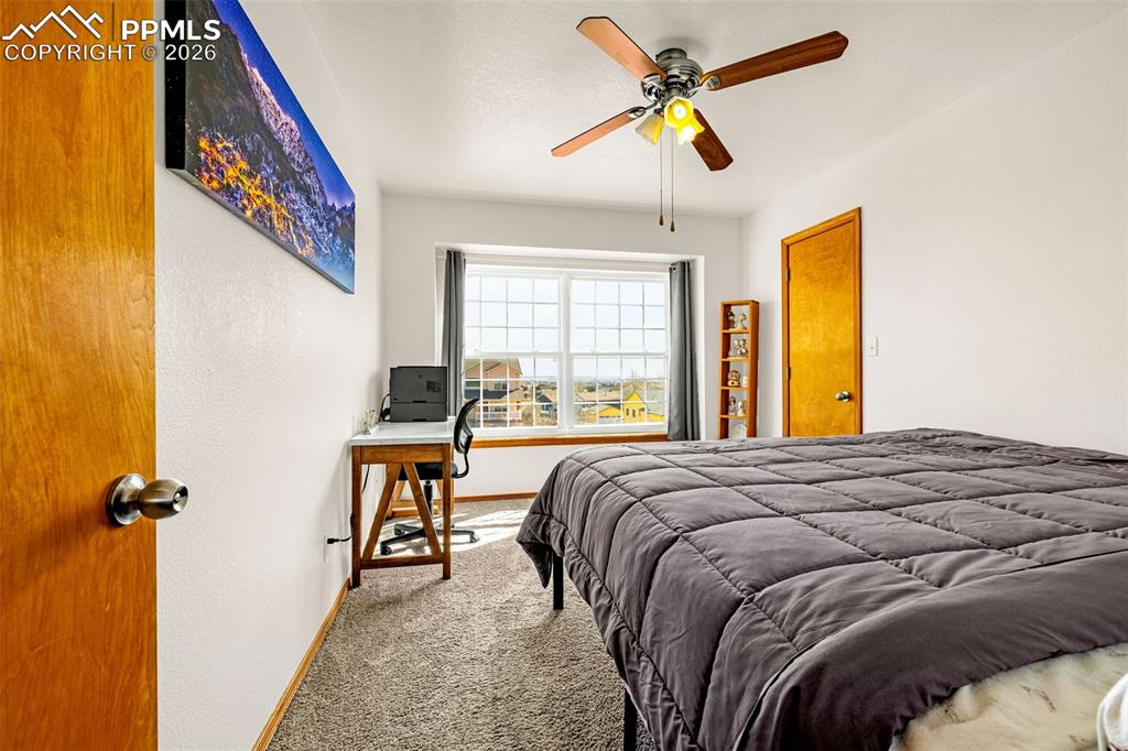 Carpeted bedroom featuring baseboards and ceiling fan