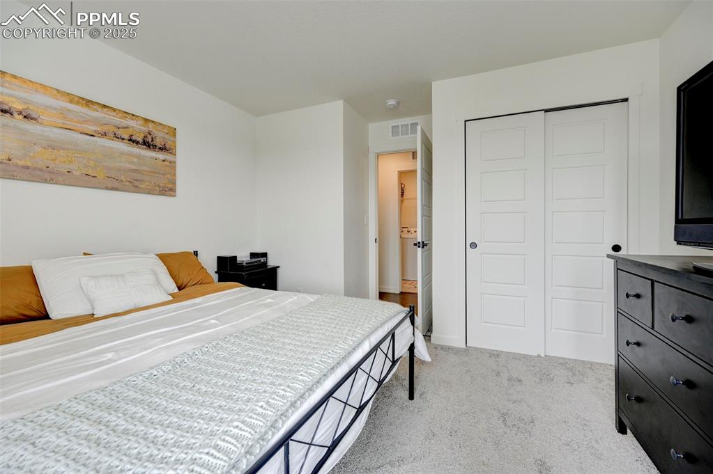 Bedroom featuring light colored carpet and a closet