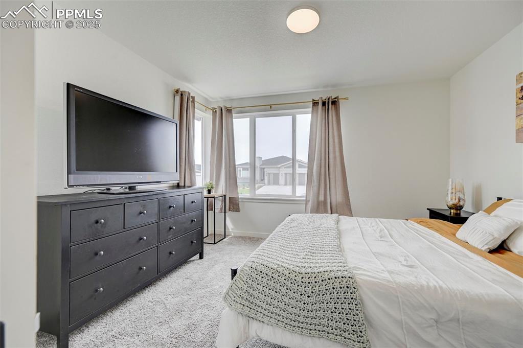 Bedroom featuring light carpet and baseboards