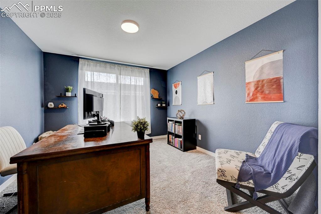 Carpeted office space featuring baseboards