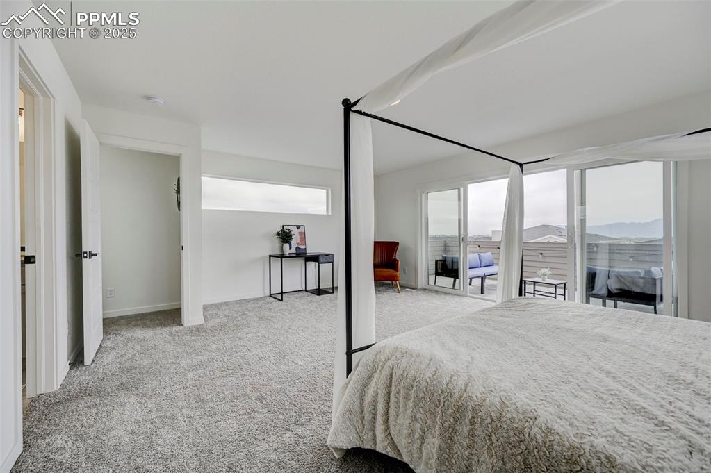 Bedroom with carpet, baseboards, and a mountain view