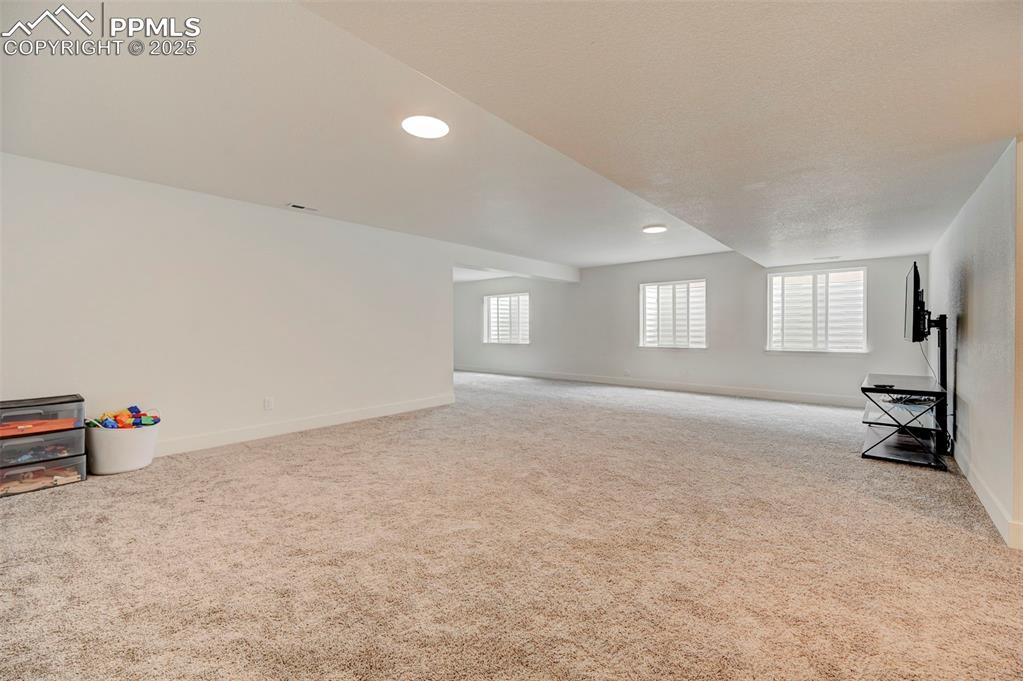 Unfurnished living room with carpet flooring, baseboards, and recessed lighting