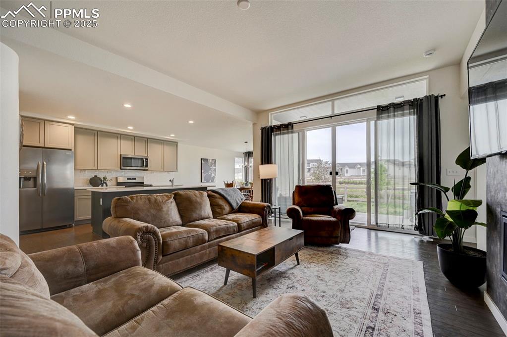 Living area featuring healthy amount of natural light, wood finished floors, and recessed lighting