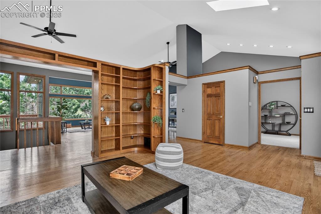 Living room featuring vaulted ceiling, wood finished floors, and ceiling fan