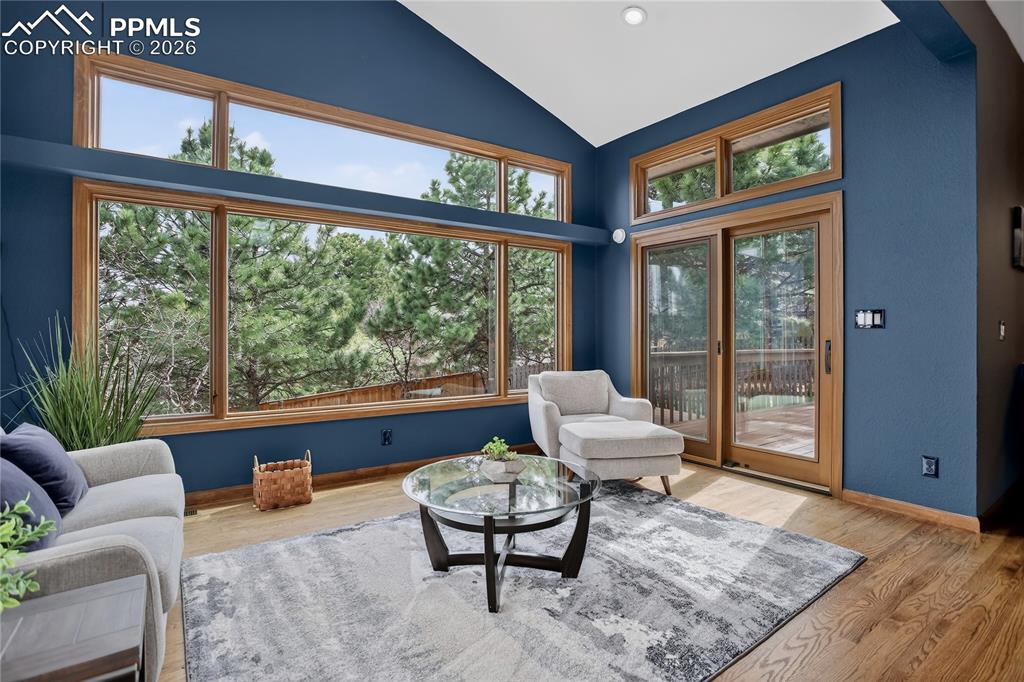 Living area with wood finished floors and vaulted ceiling