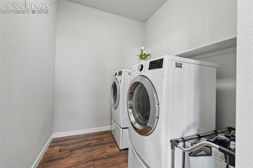 Main Level Laundry area featuring dark wood-style floors, washer and dryer, and a textured wall