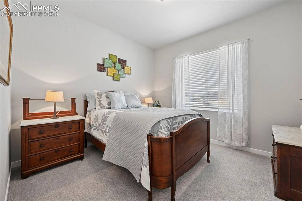 2nd Main Level Bedroom featuring light colored carpet and baseboards