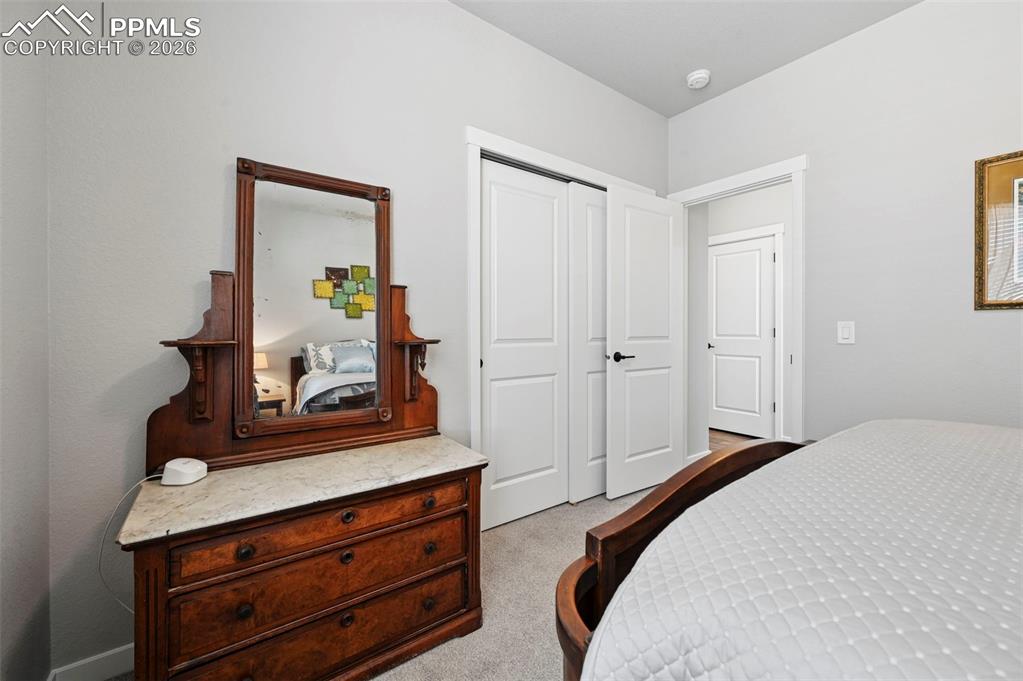 2nd Main Level Bedroom with light colored carpet and a closet