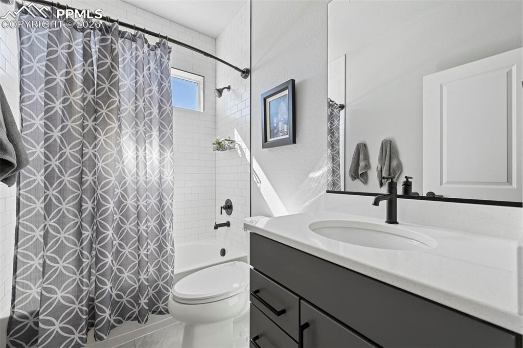 2nd Main Level Bathroom with vanity, shower / bath combo with shower curtain, and a textured wall