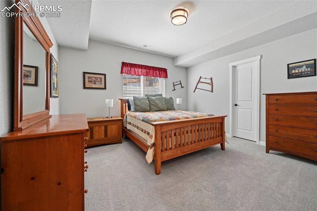 3rd Bedroom - Basement - Bedroom featuring light carpet and a textured ceiling