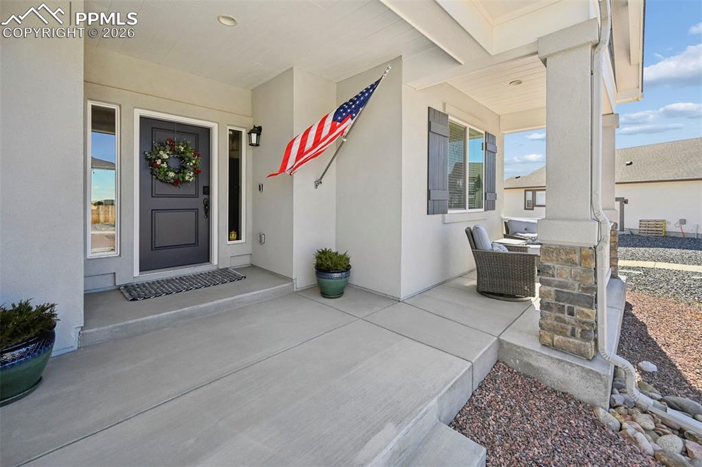 Property entrance featuring a porch and stucco siding