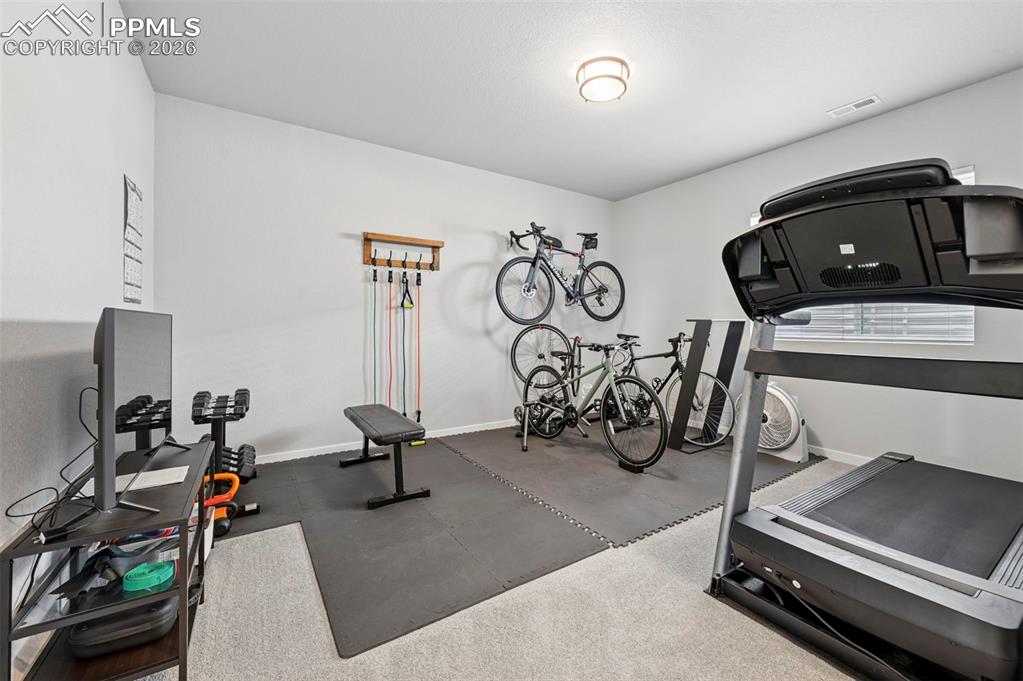 5th Bedroom - Exercise area featuring rubber floors and baseboards