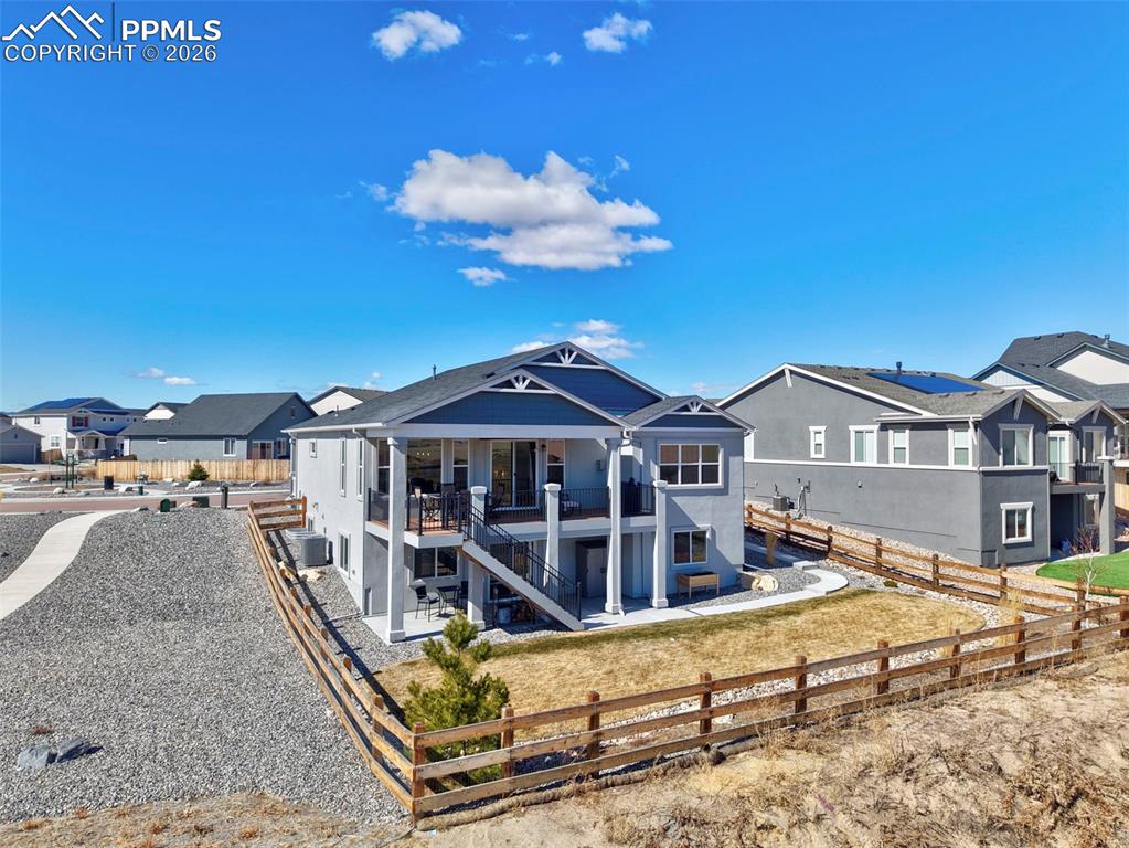 Back of house featuring a fenced backyard, a residential view, and a patio area