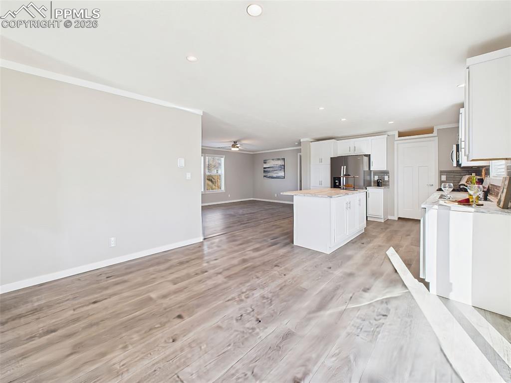 Unstaged Formal Dining Space – A blank canvas with abundant room for a formal dining setup or secondary living space, highlighted by modern lighting and wide-plank floors.