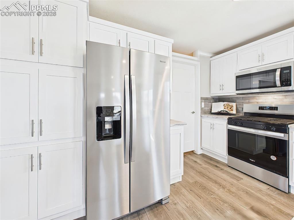 Kitchen Detail – A closer look at the kitchen showcases a full suite of stainless steel appliances, abundant cabinet storage, and modern hardware that blends style with function.