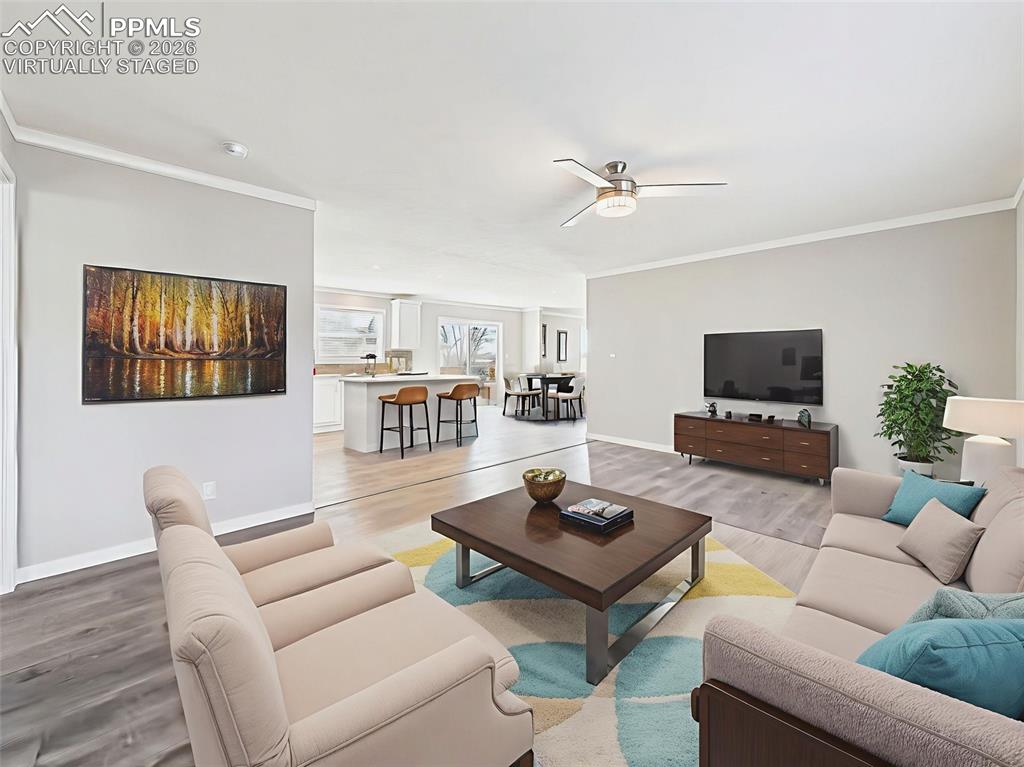 Virtually Staged View to Kitchen – With barstools at the island and a cozy living space nearby, this staging highlights the kitchen’s central role in the home’s open-concept design.