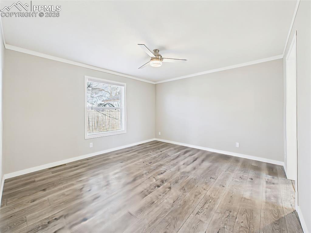 Primary Bedroom (Unstaged) – The oversized layout offers excellent flexibility and features a large window for natural light and a ceiling fan for added comfort.