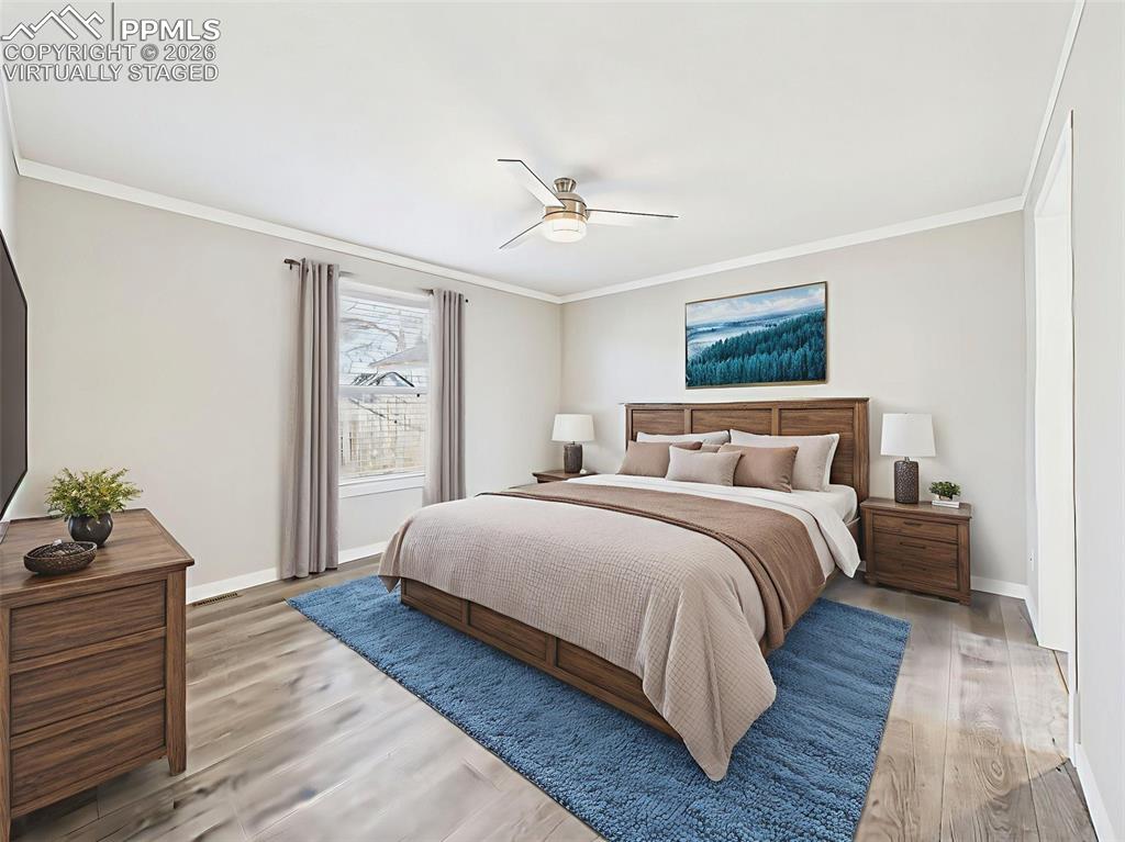 Virtually Staged Primary Bedroom – This spacious primary suite is styled with warm wood furnishings and a calming palette, showcasing room for a king-sized bed and more.