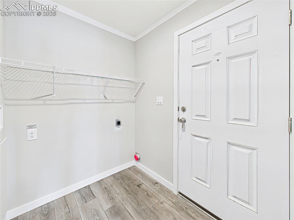 Laundry Room / Mudroom Entry – A bright and functional space with washer/dryer hookups, a wall-mounted shelf, and direct access to the exterior door.
