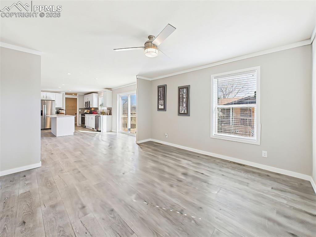 Living Room & Kitchen View – A bright and expansive layout connects the living room and kitchen, featuring luxury vinyl plank flooring and access to bedrooms and baths.