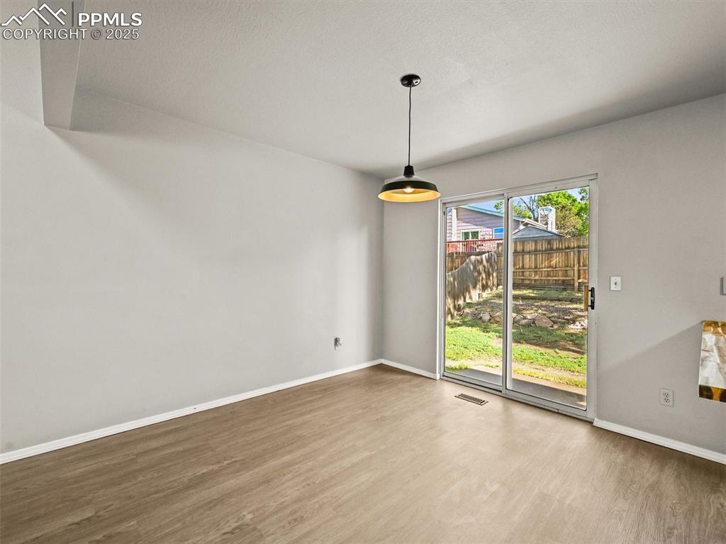 Unfurnished dining area featuring wood finished floors and baseboards