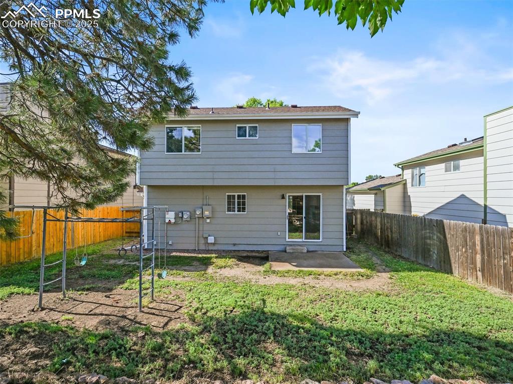 Back of property with a fenced backyard and a patio