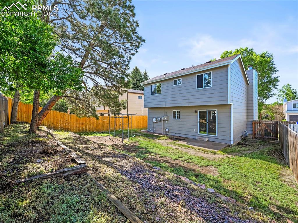 Back of house with a chimney and a patio area