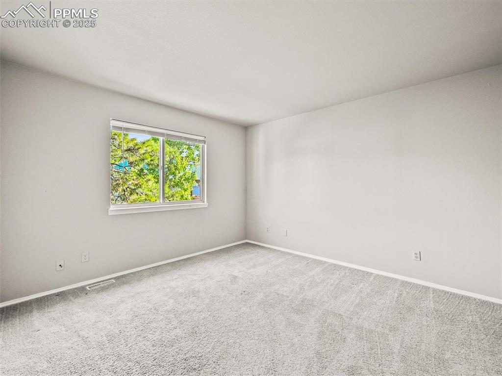 Carpeted empty room with baseboards