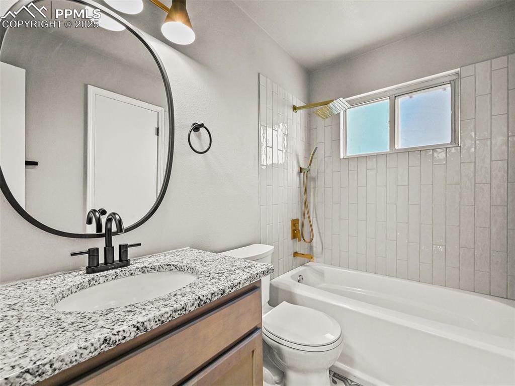 Bathroom featuring toilet, bathtub / shower combination, and vanity