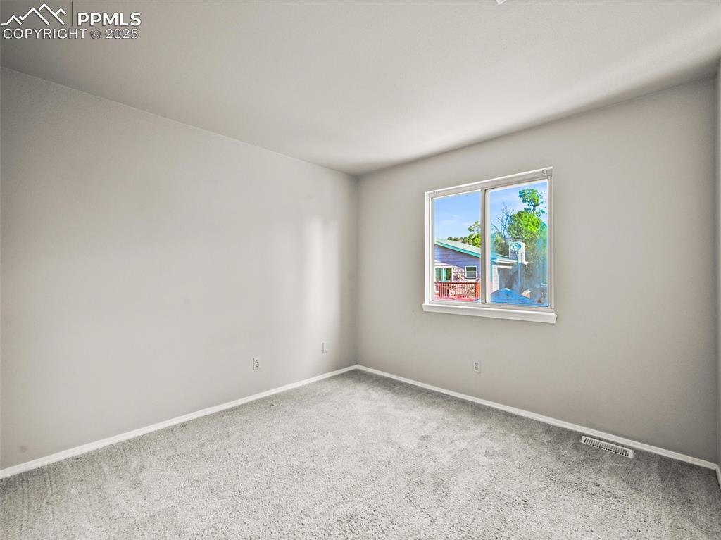 Spare room featuring carpet and baseboards