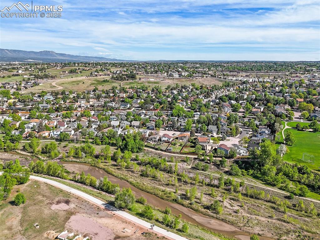 Aerial view of property's location featuring a mountain backdrop and nearby suburban area