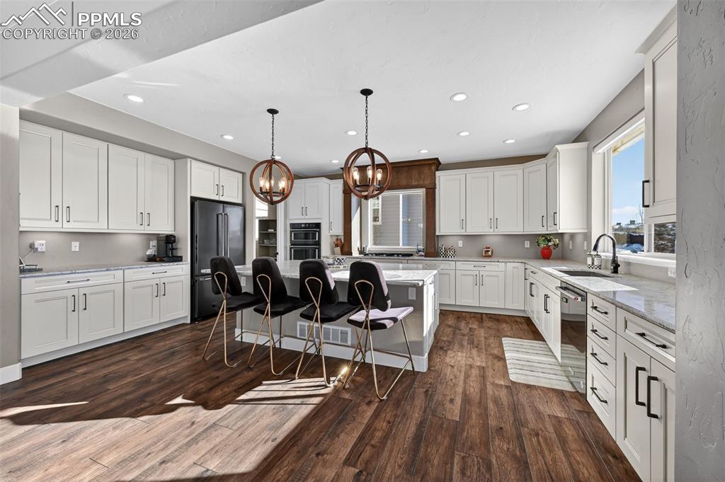 very spacious, large Kitchen, with pantry off to the left into next room. Kitchen features smart over and under cabinet lighting, view from windows of Pikes Peak. Kitchen equipped with gas range, black stainless Kitchen Aid steel appliances including dishwasher, refrigerator, oven and microwave