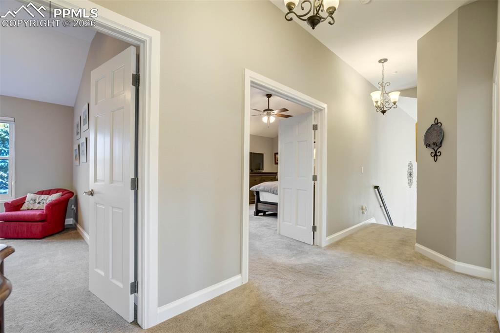 Upstairs hallway with a chandelier, carpet and showing double doors into the Primary Bedroom suite.
There is also another bedroom entrance and across from this is a huge custom fitted closet for all your linen/bathroom supplies storage needs.