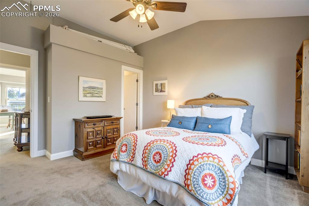 Another view of bedroom 4, the door leads to an ensuite bathroom. Ceiling fan w/lights and carpet.